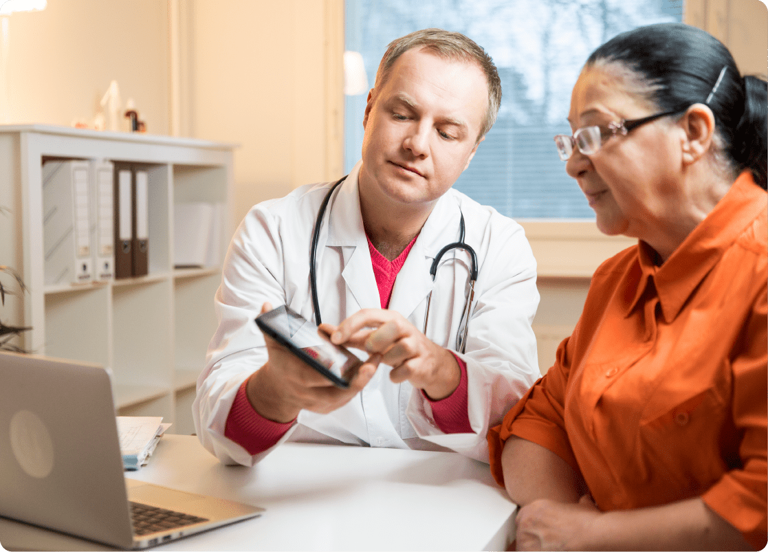 Doctor providing patient education to an older woman during consultation.