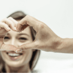 A patitent is doing her fingers like a heart with her doctors as a symbol of patient satisfaction